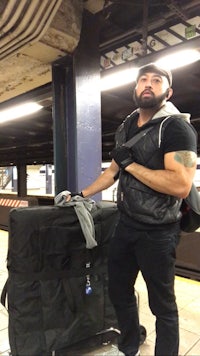 a man standing next to a black suitcase