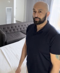 a man standing in front of a bed in a hotel room